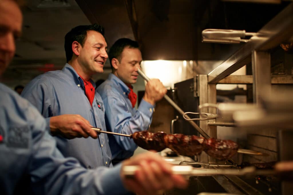 chefs preparing skewers of meat at Fogo de Chao